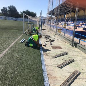 La delegación de Deportes lleva a cabo la instalación de nuevas rejillas en los canales laterales del campo municipal de fútbol